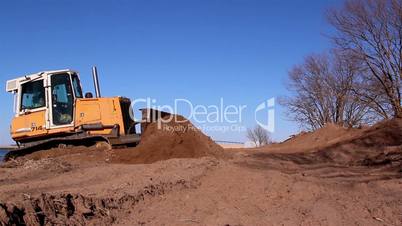 A yellow bulldozer grabbing some soil