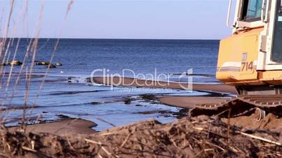 The bulldozer going back near the shore