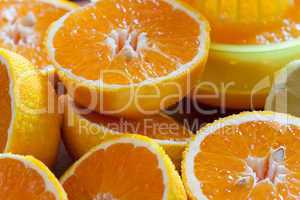 Saftige Orangen halbiert mit Zitruspresse im Hintergrund