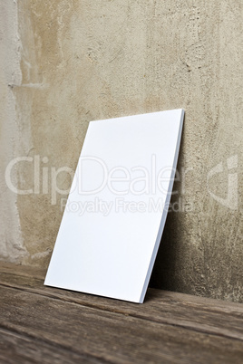 Booklet with white Cover at wooden floor and old wall