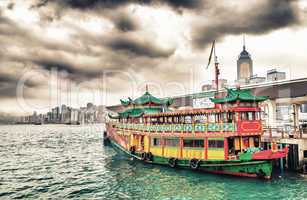 Hong Kong port. Colourful old cruise ship with city skyline on b