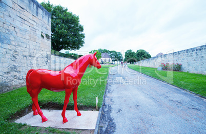 Red horse statue inside Chateau Ducal, a castle in the center of