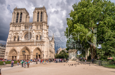 PARIS - JUNE 22, 2014: Tourists enjoy Notre Dame on a sunny day.