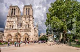 PARIS - JUNE 22, 2014: Tourists enjoy Notre Dame on a sunny day.