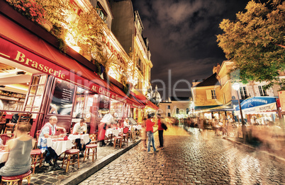 PARIS - JUNE 23, 2014: Tourists and locals walk in Montmartre st
