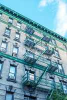 Classic New York Bowery building with green ladders for fire esc