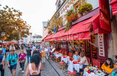 PARIS - JUNE 21, 2014: Tourists enjoy life in Montmartre narrow
