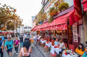 PARIS - JUNE 21, 2014: Tourists enjoy life in Montmartre narrow