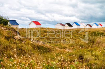 Colorful cabins along the sea. Beach huts along the ocean on a c