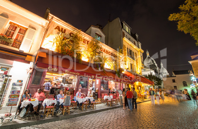 PARIS - JUNE 23, 2014: Tourists and locals walk in Montmartre st