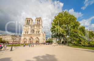 PARIS - JUNE 22, 2014: Tourists enjoy Notre Dame on a sunny day.