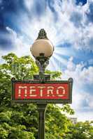 Paris, France. Classic Metro symbol. Subway sign with trees in b