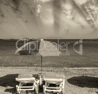 Colourful beach chairs with straw umbrellas on a beautiful sandy