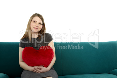 Beautyful young woman with heart shaped pillow