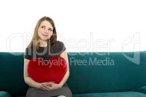 Beautyful young woman with heart shaped pillow