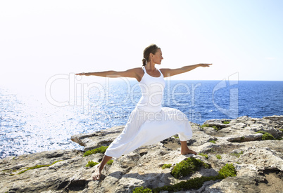 Yoga posture on rocks near the ocean