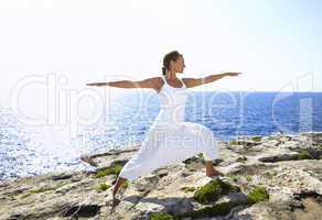 Yoga posture on rocks near the ocean