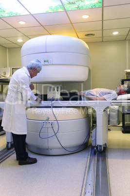 Expert male doctor with 40s male patient at MRI scanner in hospi