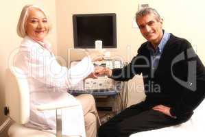 Mature female doctor examining man in 40s. Wrist and arm scan