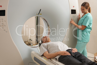 Young female doctor examining man in 40s with CT scanner. Comput