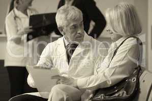 Senior male doctor showing medical results to his female woman p