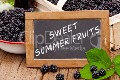 Tafel mit Text: Sweet Summer Fruits vor Brombeeren