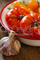 Frische Tomaten in Schale und eine Knoblauchknolle