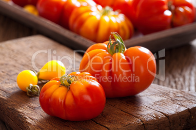 Reife Fleischtomaten auf alten rustikalen Schneidebrett