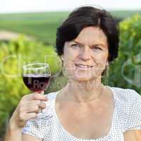 Woman in vineyard holding wine glass