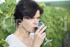 Woman in vineyard holding wine glass