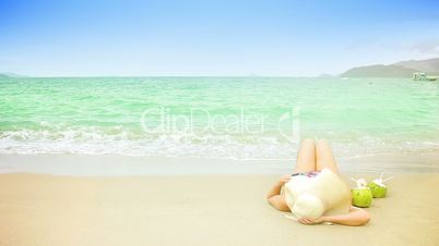 Woman laying on a sandy beach. Space for text.
