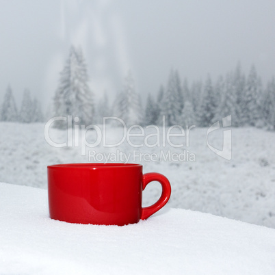 Cup is on the table in winter landscape