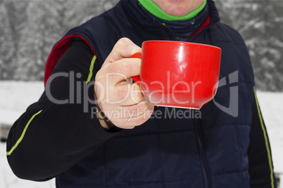 Man warms up a hot drink in the cup