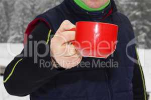 Man warms up a hot drink in the cup