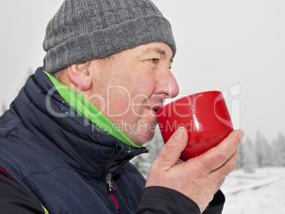 Man warms up a hot drink in the cup