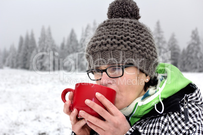 Woman with hot drink in the cup to warm