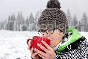 Woman with hot drink in the cup to warm