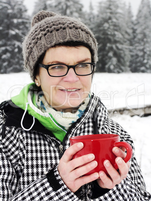 Woman with hot drink in the cup to warm
