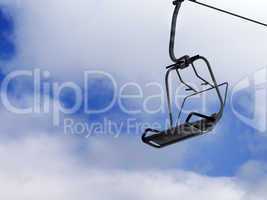 Chair-lift and blue sky with clouds