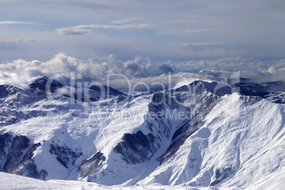 Winter mountains in clouds at windy day