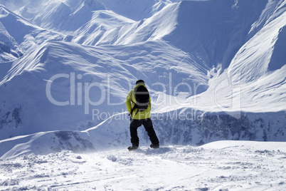 Snowboarder on top of off-piste slope at windy day
