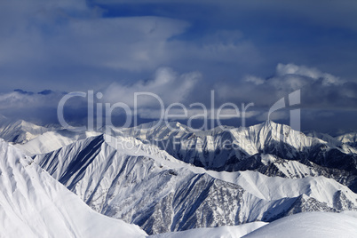 Sunlight snowy mountains and storm clouds