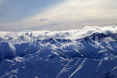 Evening snowy mountains and sunlight clouds