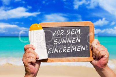 Hände halten Tafel mit Text: Vor dem Sonnen eincremen