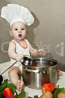 little baby in a chef's hat and ladle in hand