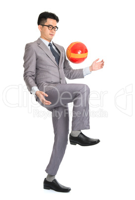 Asian businessman playing soccer