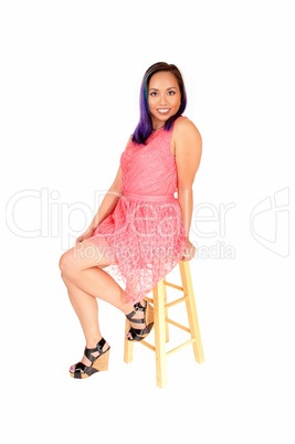 Woman sitting in pink dress.