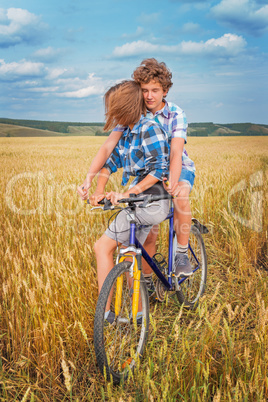 Portrait of a teen on a bicycle traveling in rye field