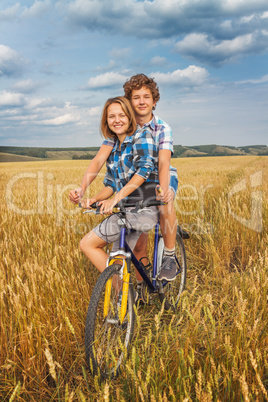 Portrait of a teen on a bicycle traveling in rye field