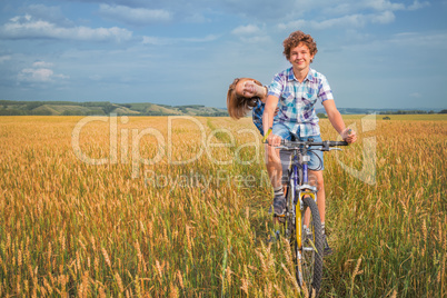 Portrait of a teen on a bicycle traveling in rye field